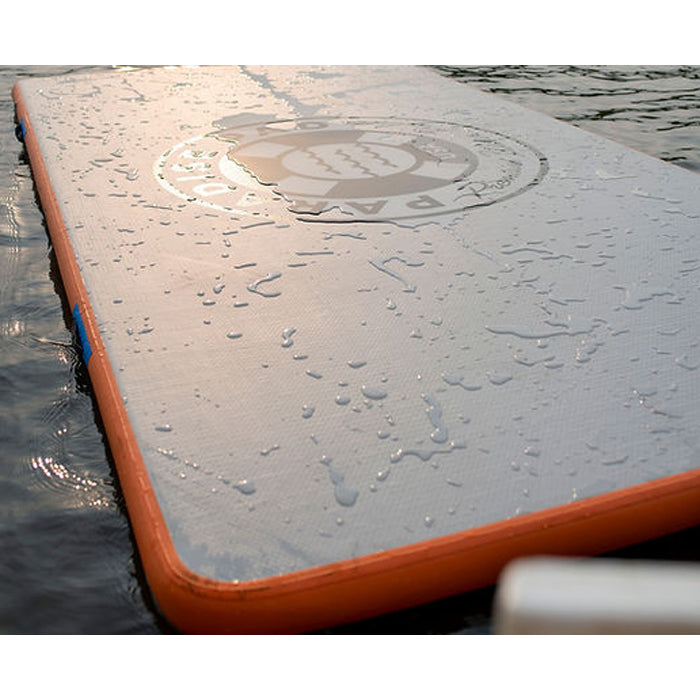Paradise Pad 6&#39;x13&#39; Inflatable Water Mat on the water with splashes of water on the mat.